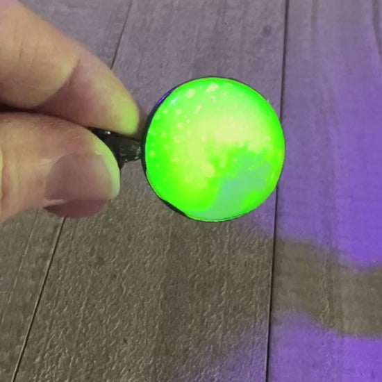 Video showing the neon yellow in the handmade resin pendant fluorescing bright green under a UV black light.