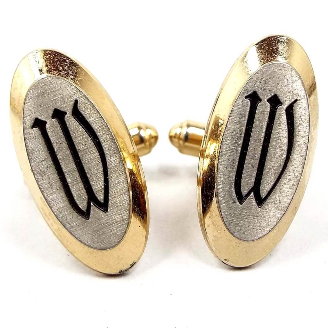 Front view of the Mid Century vintage Hickok initial cufflinks. They are mostly gold tone in color with matte silver tone color fronts. The letter W is engraved in black on the front.