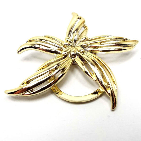 Front view of the retro vintage gold tone flower scarf clip. It has a long petal style design and a round clip on the back.