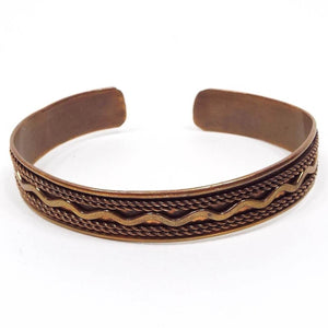 Front view of the retro vintage copper cuff bracelet. It has a rope style edge and squiggle design on the outside of the bracelet. The copper is darkened in color from age.