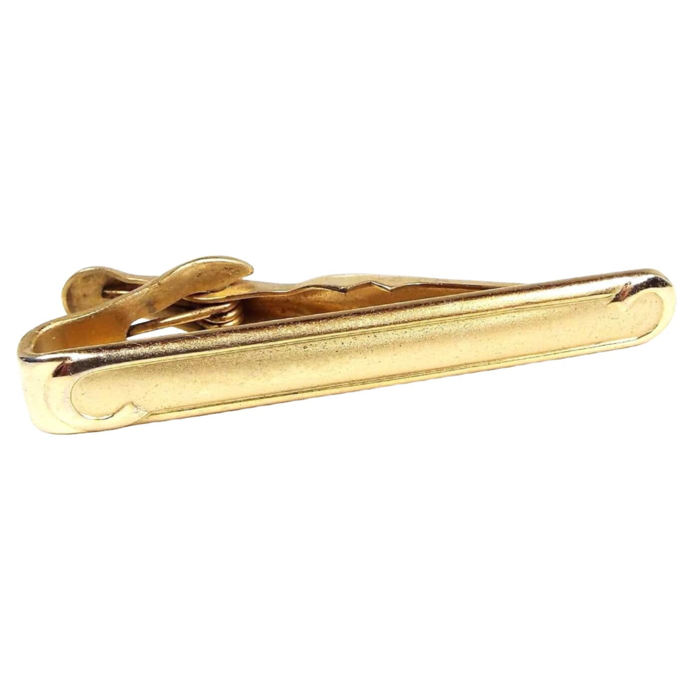 Front view of the Mid Century vintage Swank tie clip with rounded ends. It is gold tone in color and has a curl pattern on the front ends.