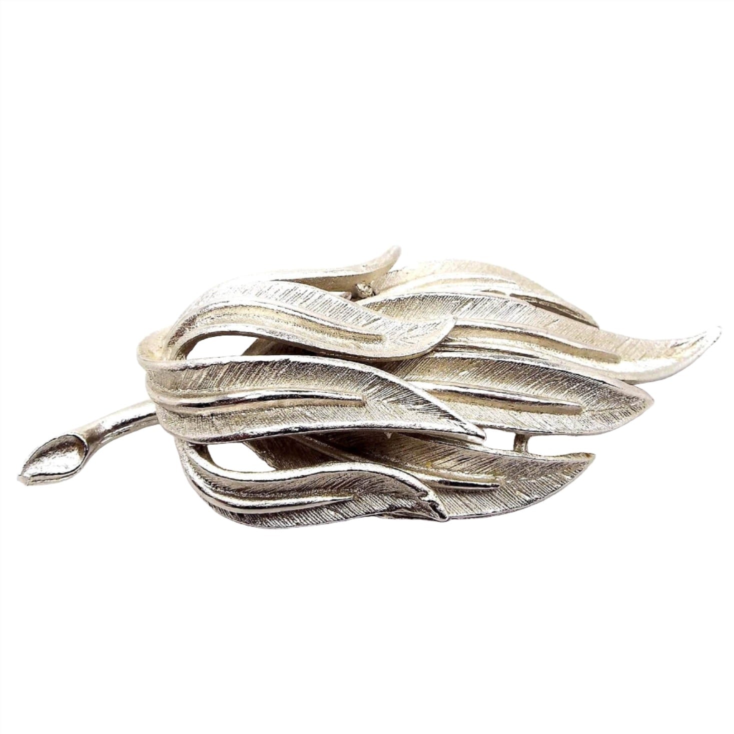 Front view of the Coro Mid Century vintage branch brooch pin. It is silver tone in color with a matte textured design of long leaves on the end.