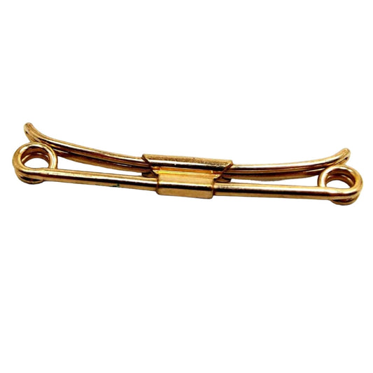 Side view of the Mid Century vintage Swank gold filled collar clip. It is a darker gold tone in color with spirals on the ends. 