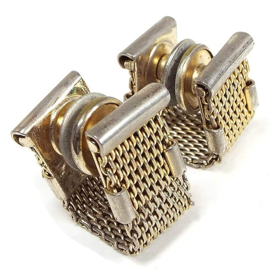 Angled side view of the Mid Century vintage wrap around cufflinks. They have a basic gold tone mesh design with a silver tone bar at the top one each side. They snap together in the middle.