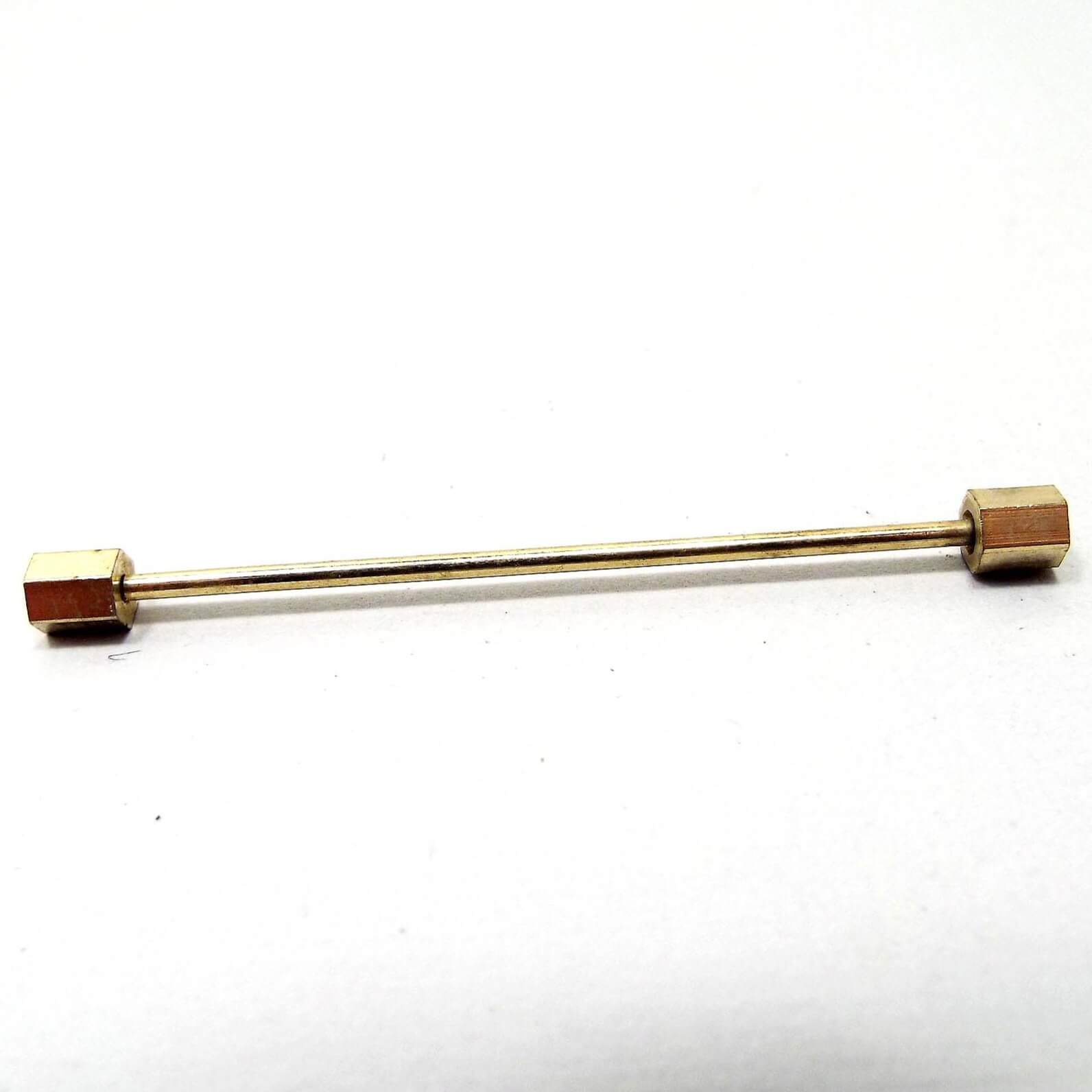 Side view of the Mid Century vintage collar bar. It is gold tone in color and has hexagon ends.