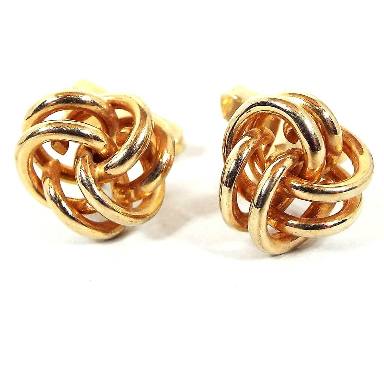 Front view of the retro vintage Swank knot cufflinks. The metal is gold tone in color. They are shaped like open double wires twisted into a knot shape.