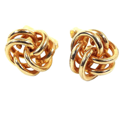 Front view of the retro vintage Swank knot cufflinks. The metal is gold tone in color. They are shaped like open double wires twisted into a knot shape.