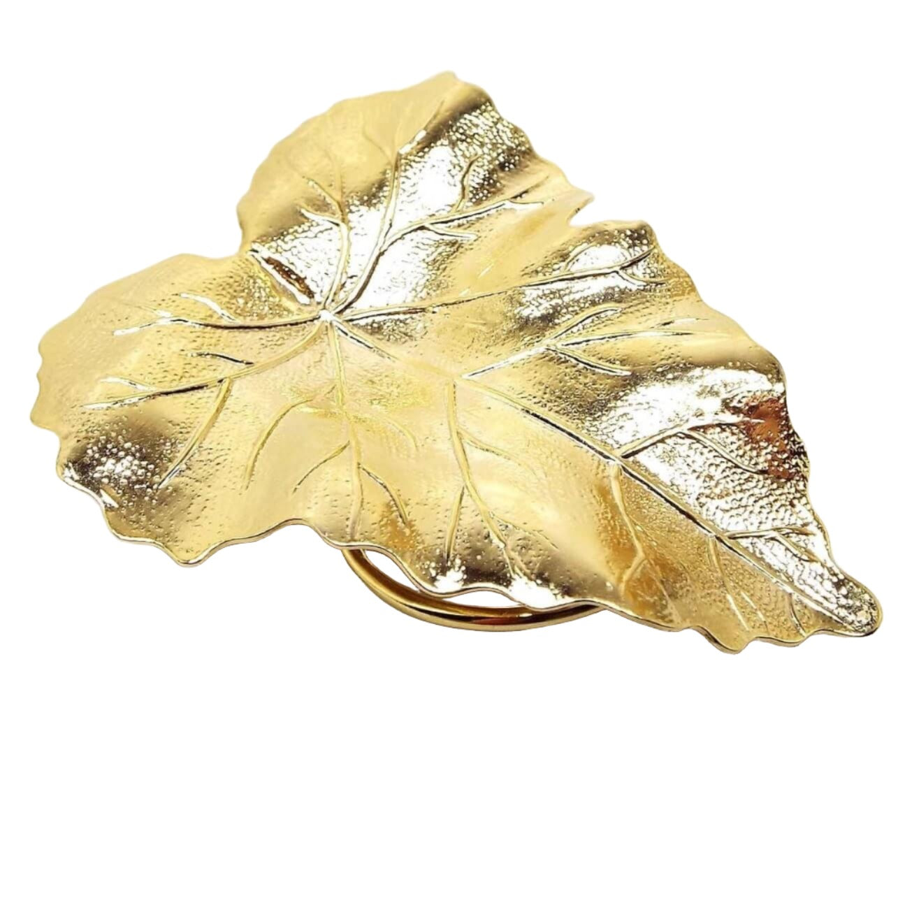 Top view of the large retro vintage leaf scarf clip. It is gold tone in color and has a detailed leaf design with lightly textured metal. Part of the round ring clip on the back is showing in the photo.