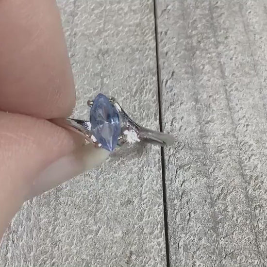 Video of the retro vintage rhinestone ring to show how the rhinestones sparkle. The metal is silver tone in color. There is a marquis shaped light blue rhinestone at the top and a small clear round one on the side of it.