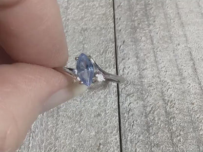 Video of the retro vintage rhinestone ring to show how the rhinestones sparkle. The metal is silver tone in color. There is a marquis shaped light blue rhinestone at the top and a small clear round one on the side of it.