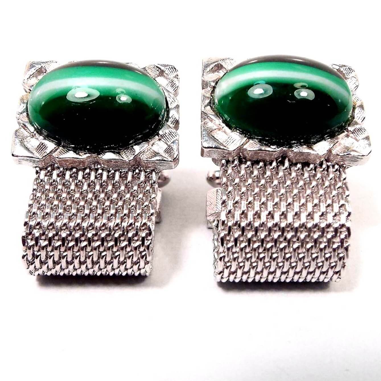 Front view of the 1950's Mid Century vintage Dante wrap around cufflinks. The metal is silver tone in color. There are large oval glass cabs at the top that are dark green with a stripe of light green and white through the middle. There is silver metal mesh coming down from the bottom and around to the back of the cufflinks.