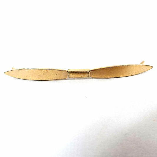 Front view of the Mid Century vintage collar clip. It's gold tone in color and flares out in the middle then goes out to pinched ends.