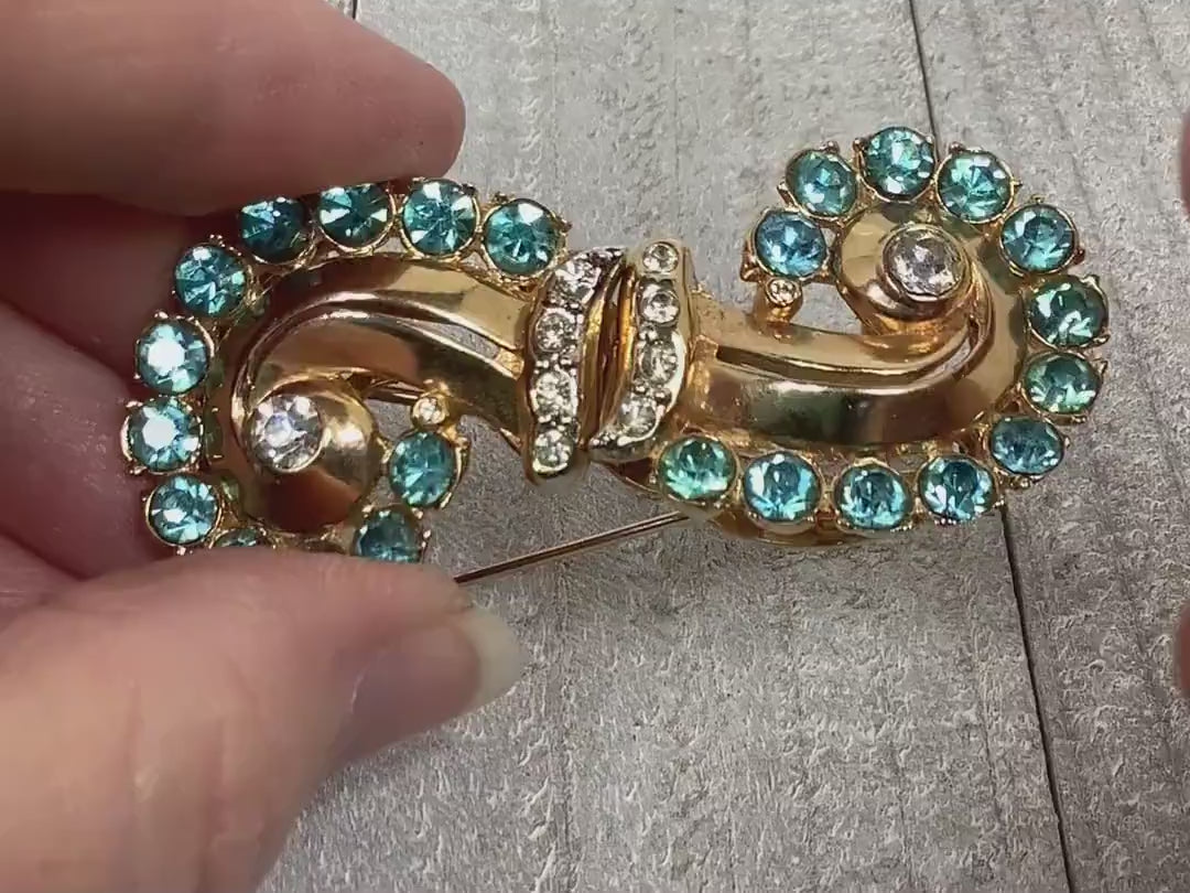Video of the 1930's Coro duette brooch fur clip combo. The video shows how the rhinestones sparkle and how the brooch comes apart to form two fur clips if you choose to wear them that way.