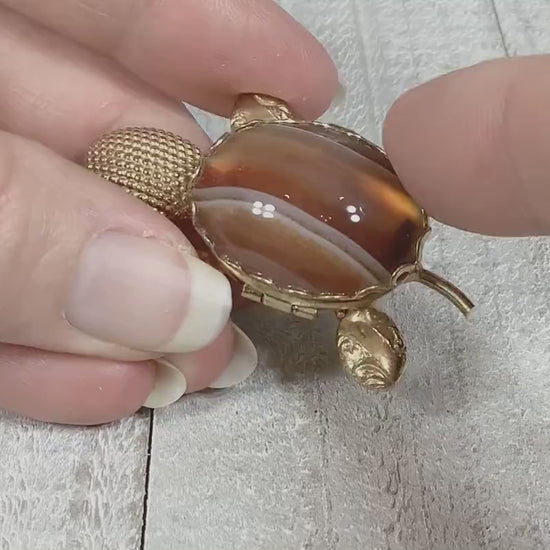 Video showing opening and closing the small compartment on the shell of the retro vintage turtle brooch pin.