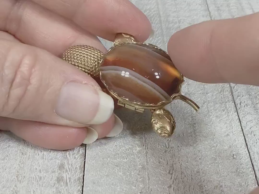 Video showing opening and closing the small compartment on the shell of the retro vintage turtle brooch pin.