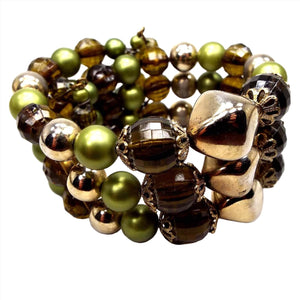 Front view of the Mid Century vintage Fall style memory wire bracelet. It has three rows of plastic chunky beads in metallic green, faceted brown, and metallic gold color. Some of the metallic coating on the beads is worn some for a lighter color in areas.