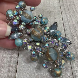 Video showing the sparkle on the AB blue rhinestones for the Mid Century vintage rhinestone and plastic beaded large cluster spray brooch pin.