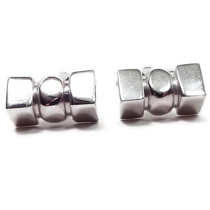 Front view of the Shields Mid Century vintage cufflinks. They are silver tone in color and have a 3D style shape with rectangles on each side and an oval in the middle.