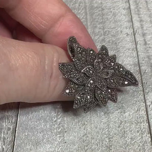 Video showing the sparkle on the marcasites on the retro vintage sterling silver marcasite ring. It is a large abstract flower shape with metallic gray sparkling cut stones.