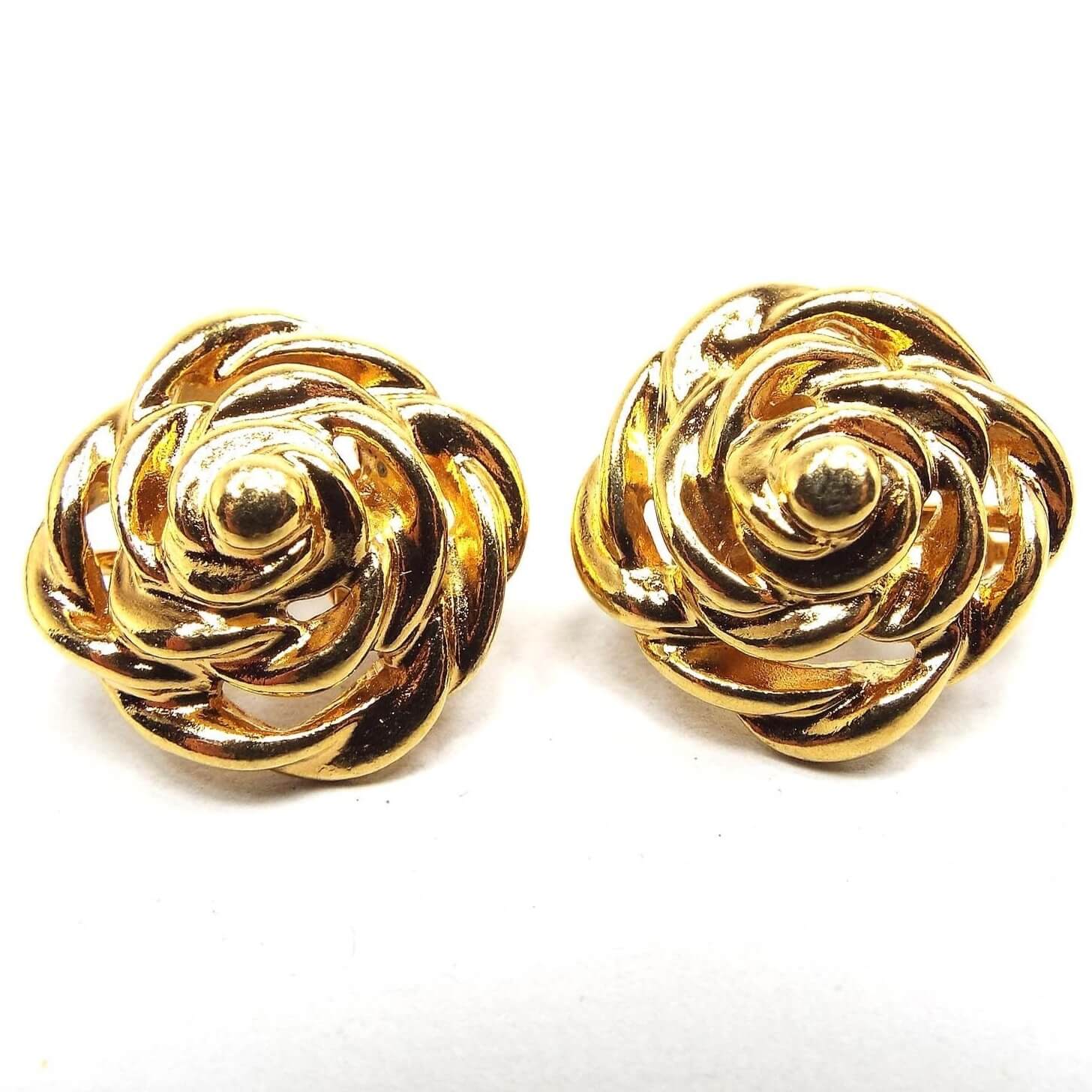 Front view of the retro vintage swirl earrings. They are gold tone in color and have a swirled and curved flower like design.