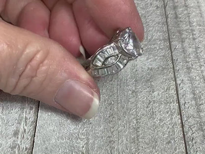 Video of the retro vintage sterling silver CZ heart ring. There is a large heart shaped cubic zirconia stone at the top. There are two curved bands on either side with marquis and trapezoid shaped cubic zirconia. The video shows how much the CZ stones sparkle and all the glitz and glam of the ring.