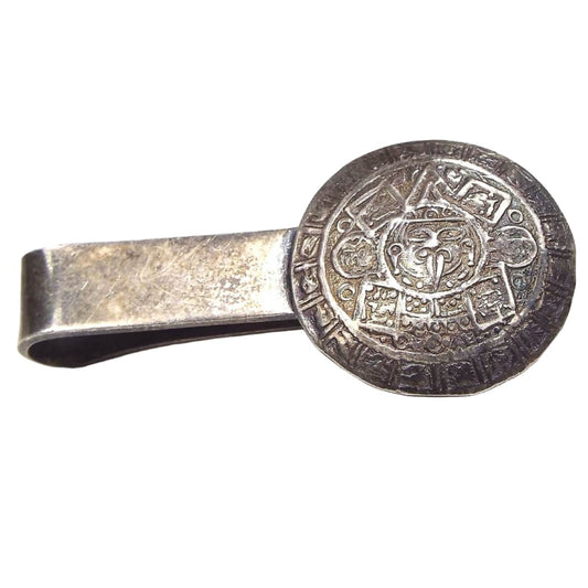 Front view of the JE Mid Century Vintage tie bar. The sterling silver is very darkened from age. It's a slide on style tie bar with an Aztec Calendar design on the end. 