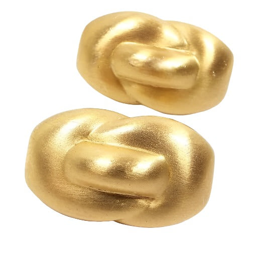 Front view of the retro vintage Monet clip on earrings. They are brushed matte gold tone in color. They have an oval knot style design.