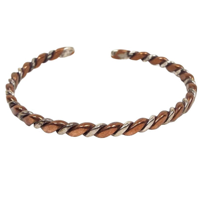 Front view of the retro vintage two tone cuff bracelet. It has a twisted design with copper and silver tone color metal.