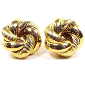 Front view of the retro vintage knot earrings. They are gold tone in color and have curved bands of textured matte metal and shiny metal.