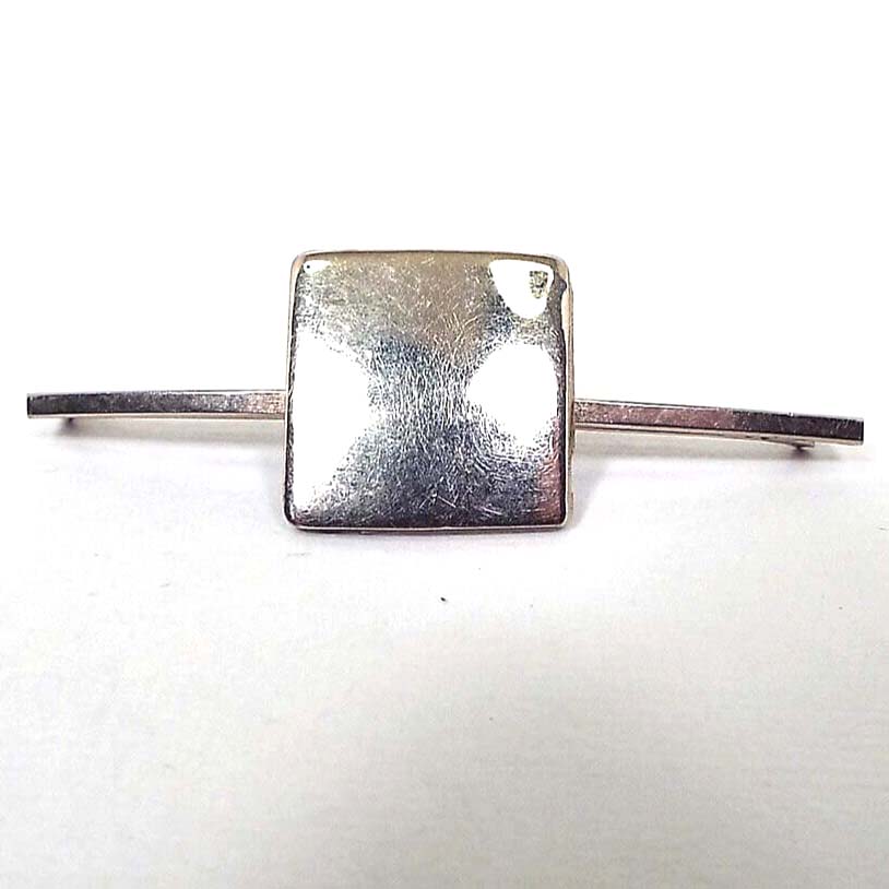 Front view of the Mid Century vintage square collar clip. The metal is silver tone in color. There is a squared bar on either side of a large square in the middle. 