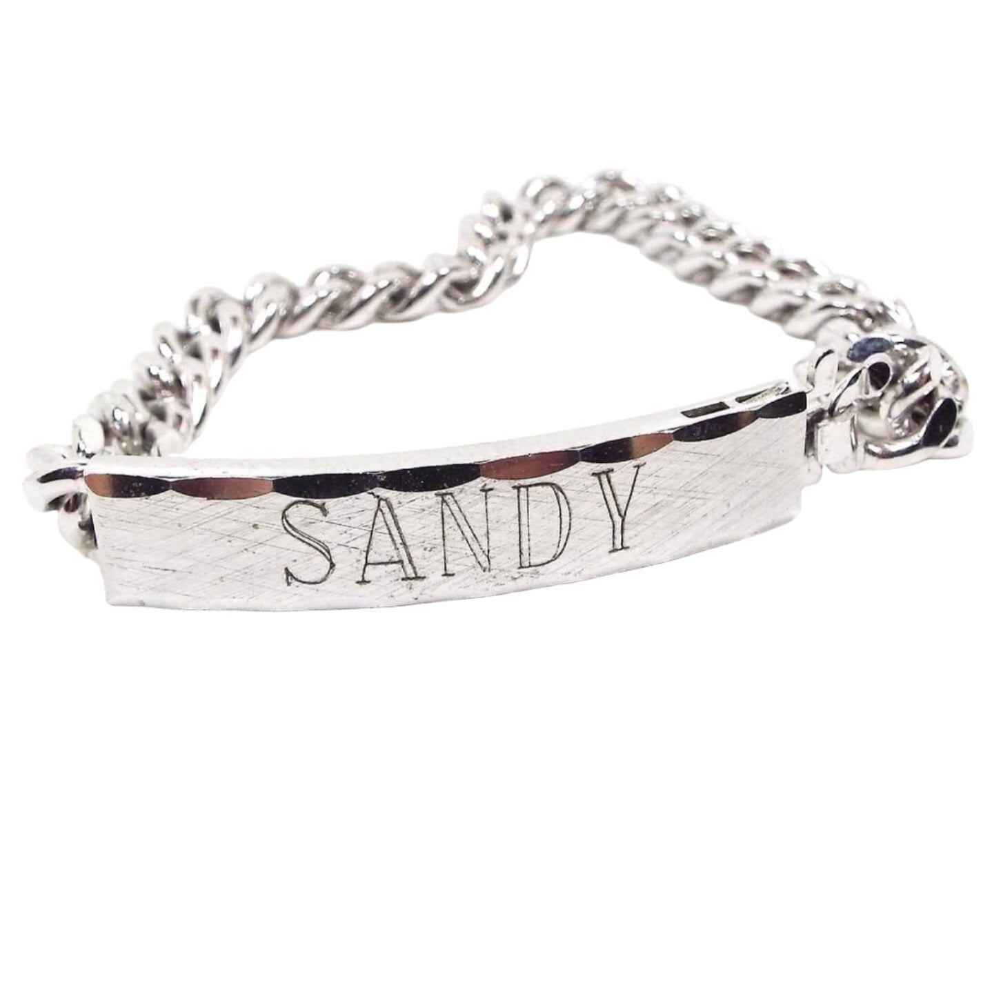 Front view of the retro vintage Speidel ID bracelet. It is silver tone in color. The front curved bar has a brushed matte front with the name Sandy engraved on it. The top and bottom edge are faceted.