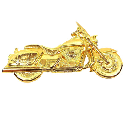 Front view of the retro vintage JJ motorcycle brooch pin. It is gold tone in color. It's shaped like a detailed cruiser style bike with a saddle bag. 