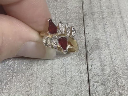 Video of the retro vintage Vargas rhinestone ring. There are two teardrop red rhinestones at the top with smaller round clear rhinestones on either side. The video shows how they sparkle. 