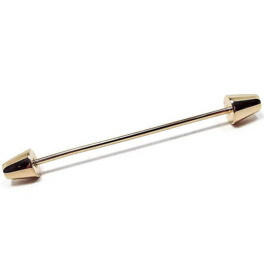 Front view of the 1950's Mid Century vintage collar bar. The metal is gold tone in color. There is a thin rounded bar in the middle with a cone shaped end on each side.