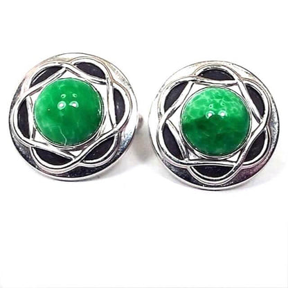 Front view of the Mid Century vintage Anson cufflinks. They are round and silver in color. In the middle of each one is a rounded fancy glass cab that is marbled with shades of green and a little bit of white. Around the glass cabs is a woven Celtic style design. 