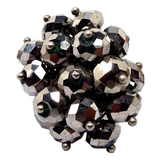 Top view of the retro vintage cluster beaded adjustable ring. The beads are faceted rondelles that are metallic gray for a faux hematite look. There are tiny silver tone round beads at the end of each one. The beads form a large cluster on top. 