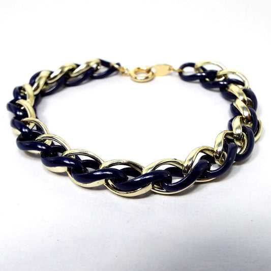 Front view of the retro vintage Trifari twisted chain bracelet. Some of the links are gold tone in color and the middle ones are enameled in a very dark blue color. 
