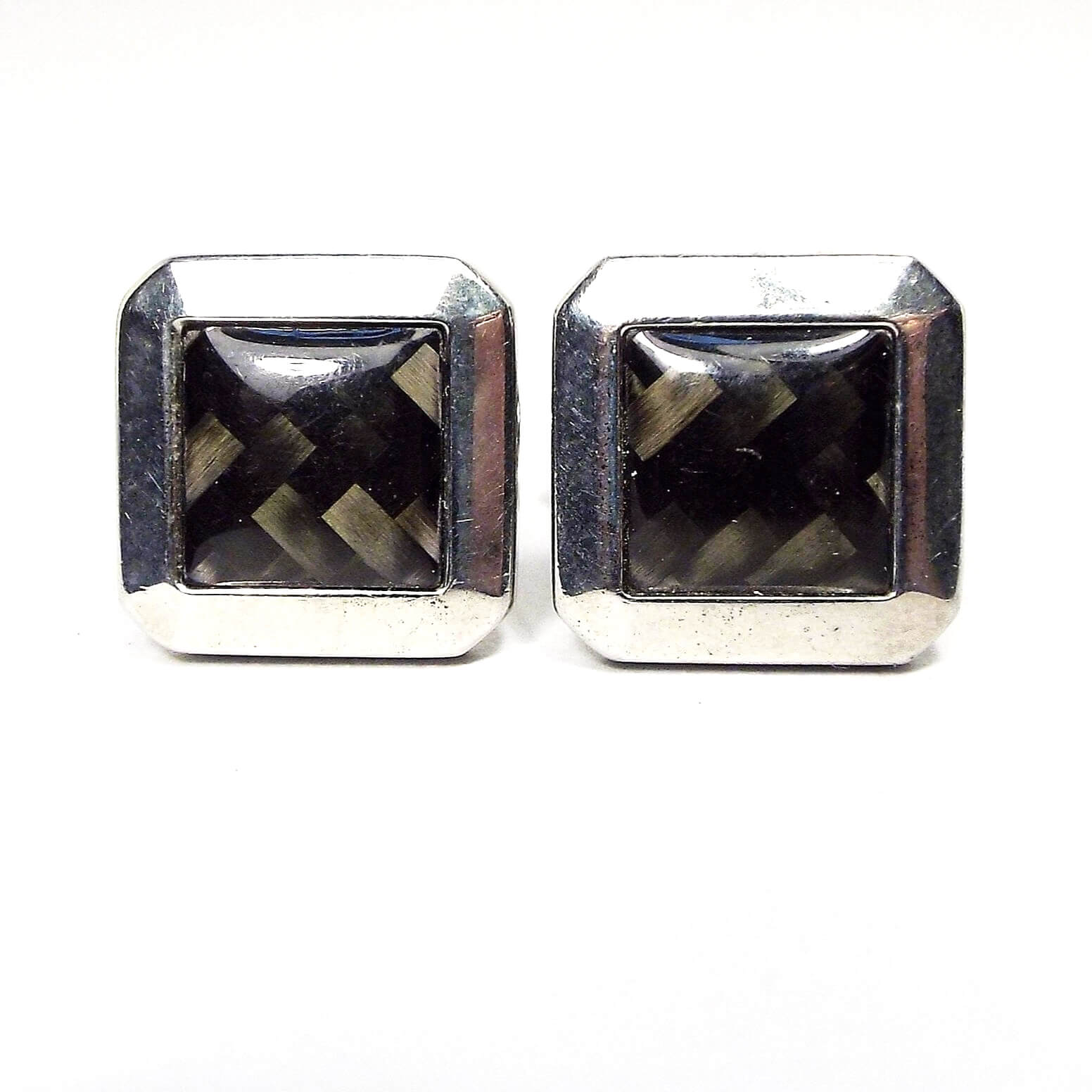 Cufflinks are octagon in shape that look like squares with angled corners. They are silver in color. Middle of cufflinks have a basket weave design in shades of brown and gray with a rounded clear resin top. 