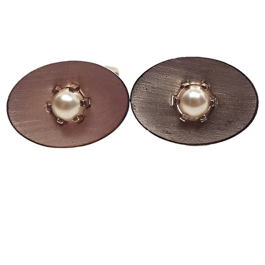 Front view of the Mid Century vintage Anson cufflinks. They are Oval in shape with a matte brushed gold tone color. In the middle there is an imitation pearl on each one with a prong setting.