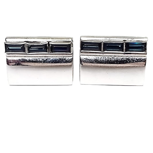 Front view of the Anson Mid Century vintage rhinestone cufflinks. They are silver tone in color and rectangular in shape. There is a row of 3 baguette rectangle cut blue rhinestones at the top of each cufflinks. 