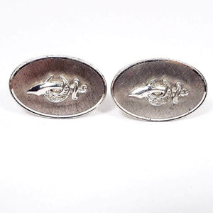 Front view of the Mid Century vintage Anson Shriners cufflinks. They are oval shaped and the sterling silver has a matte brushed texture on the front. There is the scimitar and two claws design in the middle with three tiny diamond accents on the curved part of the two claws 