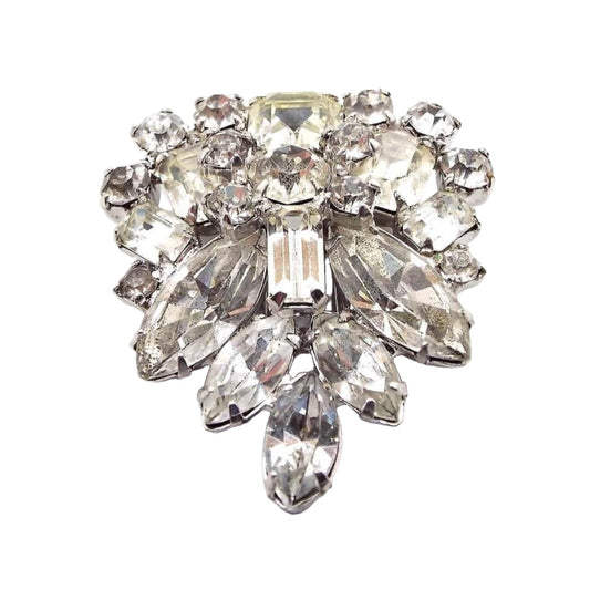 Front view of the 1940's Mid Century vintage rhinestone fur clip. The metal is silver tone in color. It has clusters of prong set clear rhinestones in marquis, round, baguette, and square shapes. The shape of the clip has rounded top sides and comes down to a point at the bottom.