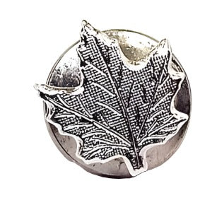 Front view of the retro vintage maple leaf tie tack. The metal is textured matte silver tone in color. It has a maple leaf shape design with etched leaf veins. The round clutch can be seen on the back and is the type with no chain.