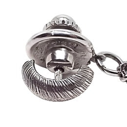 Top view of the Hickok vintage tie tack. The metal is textured matte silver tone in color. It has a bowed out U shape with diagonal lines across it. The back clutch has a chain coming off of it with a bar at the end.