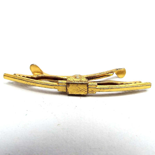 Front view of the Mid Century vintage Hickok vermeil collar clip. It is gold tone in color with some dark areas in the front middle. There is a clip on each side of the back. 