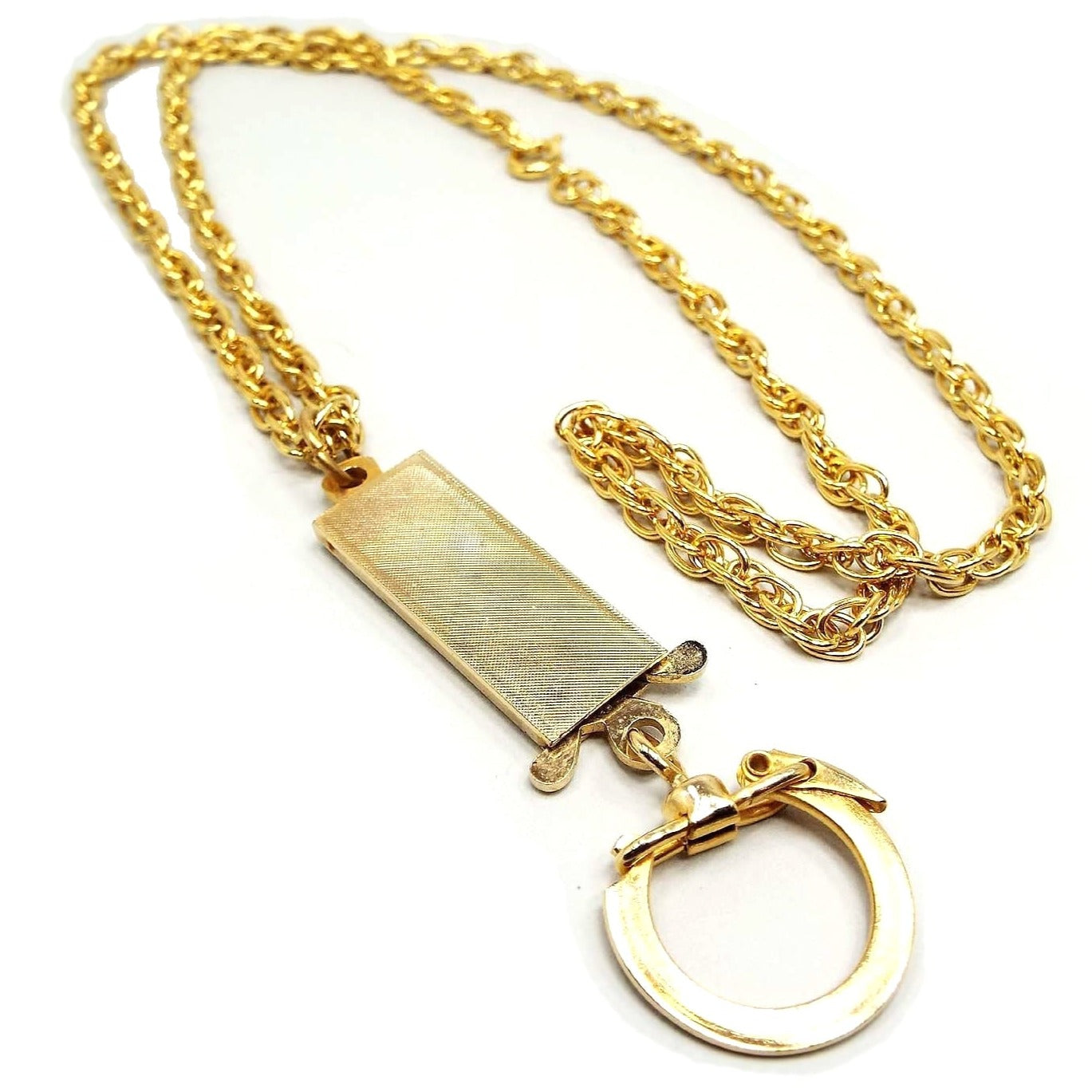 Front view of the retro vintage keychain lanyard. It has a gold tone plated rope chain with a spring ring clasp. At the bottom is a rectangular area that is textured and has a pinch style box clasp at the bottom. You can pinch the tabs together to remove the clasp holding the keychain part from the lanyard. There is a snap over style keychain ring at the very bottom.