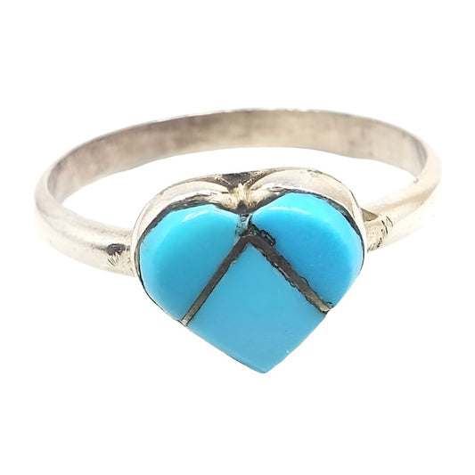 Front view of the retro vintage faux turquoise ring. The top has a heart design that's separated into three parts of left, right, and bottom. Each part has a blue glass imitation turquoise cab that is separated by metal bars between the three pieces. The band and setting are silver tone in color. 