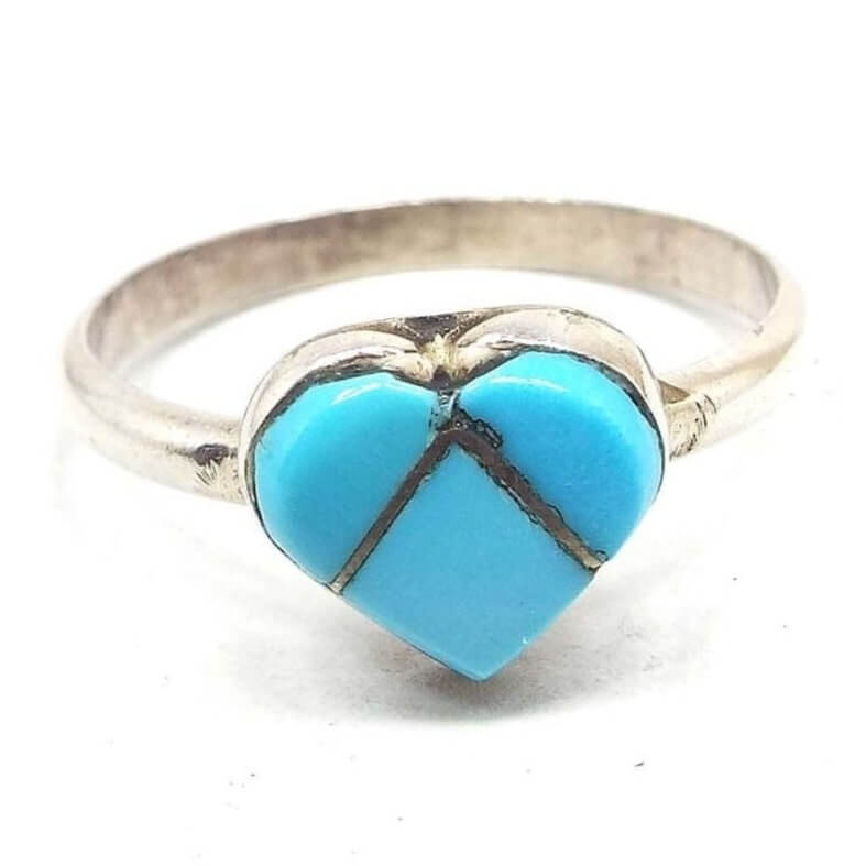Front view of the retro vintage faux turquoise ring. The top has a heart design that's separated into three parts of left, right, and bottom. Each part has a blue glass imitation turquoise cab that is separated by metal bars between the three pieces. The band and setting are silver tone in color. 