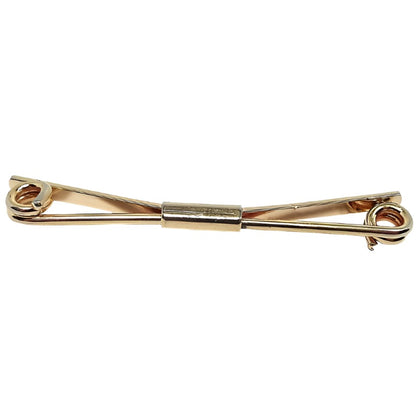 Front view of the Anson Mid Century 1960's vintage collar clip bar. It is gold tone plated in color. The front has a thick wire bar thas is spiraled inward at the ends. the back is a flat wider bar that is angled. there is a rectangle holding both bars together in the middle.