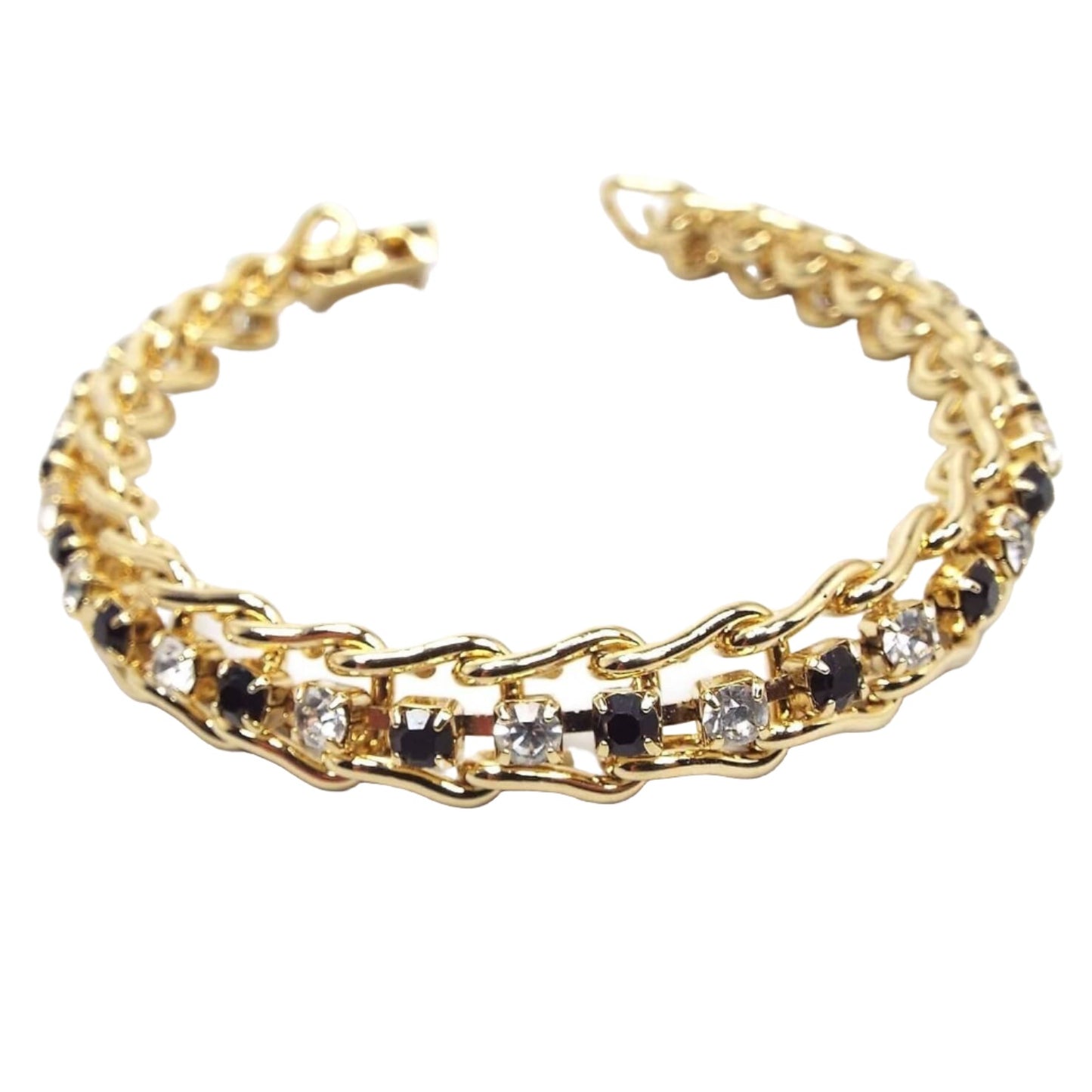 Front view of the retro vintage rhinestone bracelet. The metal is shiny gold tone in color and has sideways curved U shaped links. Inside each link is a small round rhinestone. The rhinestones alternate in color down the length of the bracelet in black and sparkling clear. There is a snap lock clasp at the end.